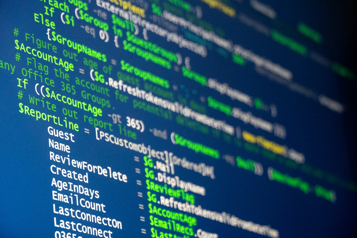 Multiple monitors displaying code in a dark room for JSON data manipulation